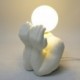 Lampe veilleuse Personnage en porcelaine, tête en sphère lumineuse entre les mains, hauteur 25 cm